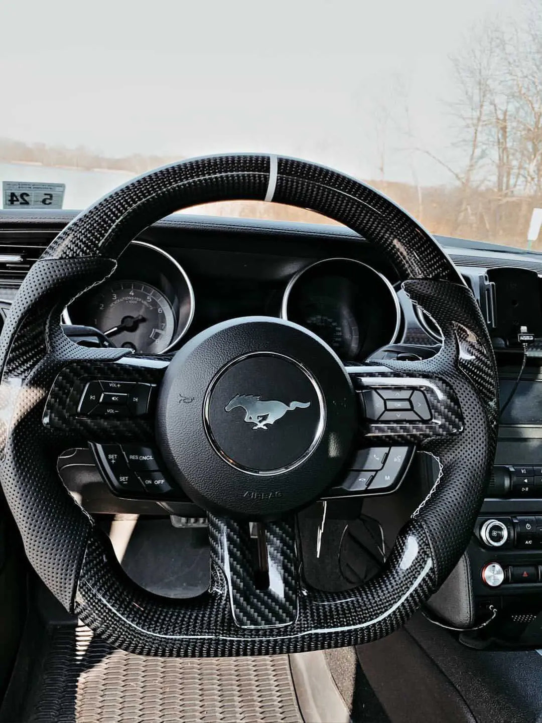 A relevant stock photo of carbon fiber steering wheel in a typical setting.