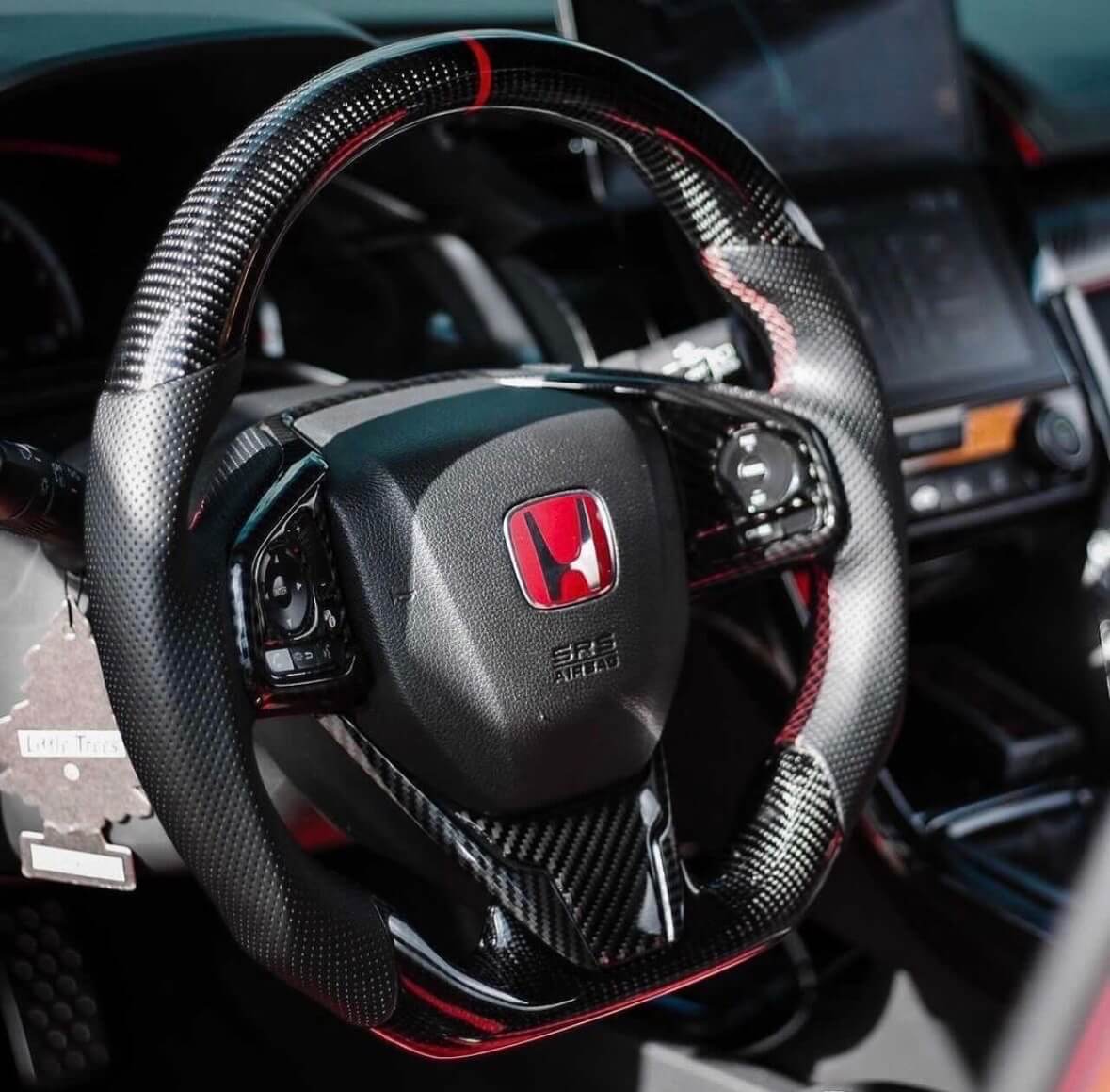 A relevant stock photo of carbon fiber steering wheel in a typical setting.