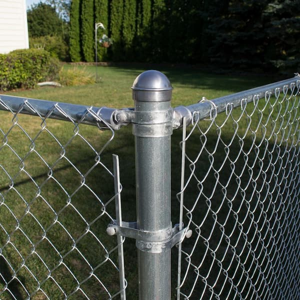 A relevant stock photo of chain link fence post in a typical setting.