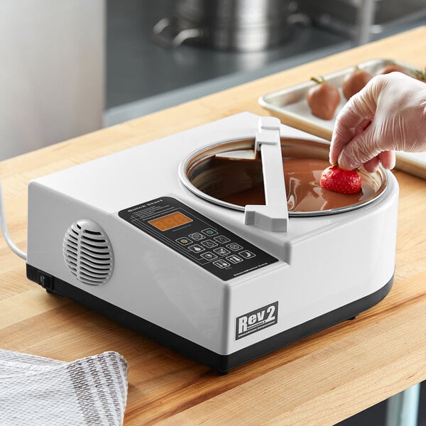 A relevant stock photo of chocolate tempering machine in a typical setting.