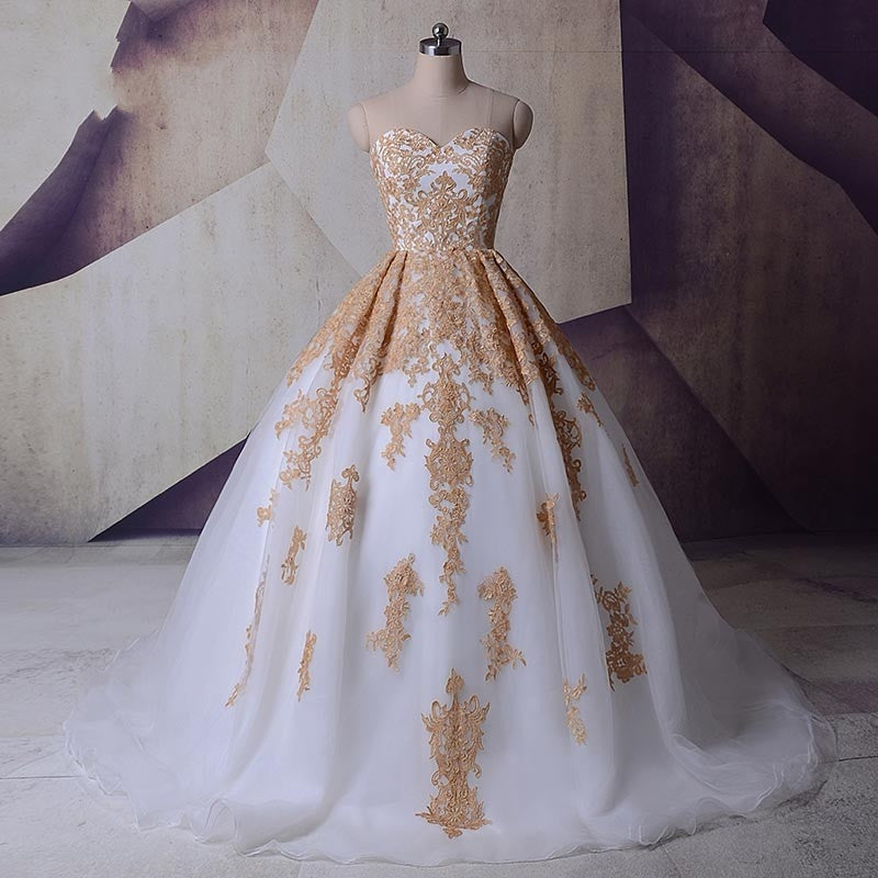 A relevant stock photo of gold wedding dresses in a typical setting.