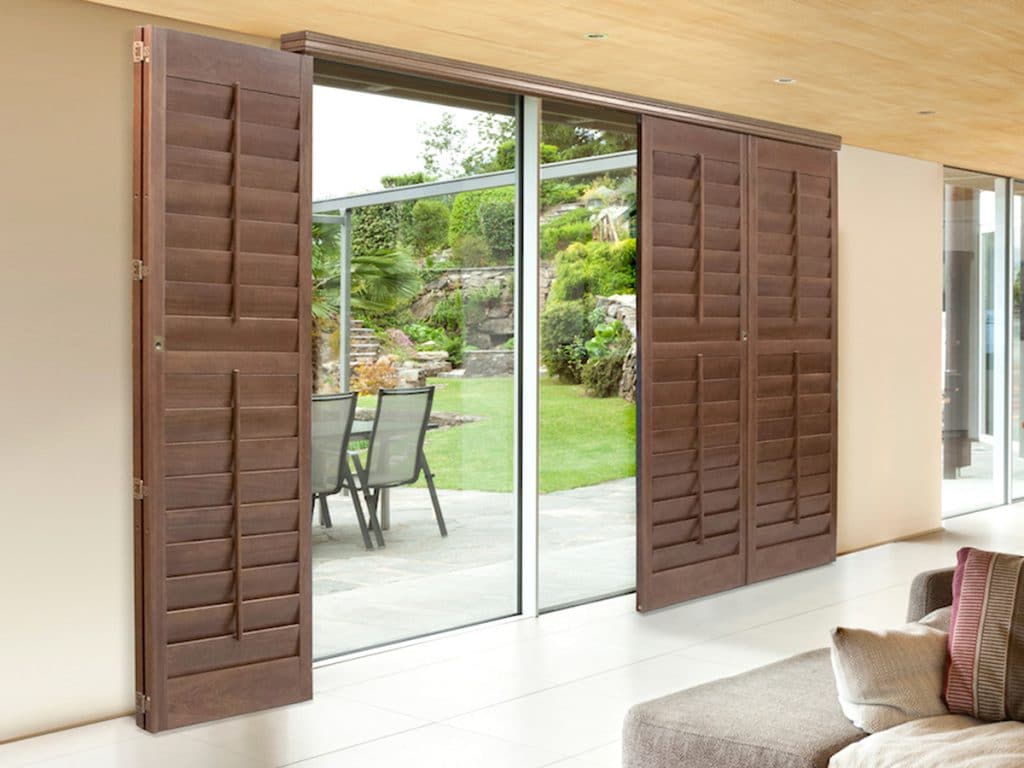 A relevant stock photo of plantation shutters for sliding glass doors in a typical setting.